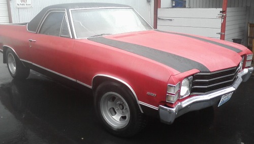 Ford El Camino with spray paint repair and black racing stripes painted on it